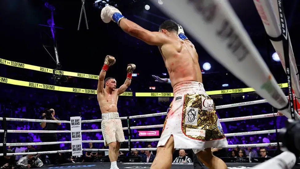 Teofimo Lopez and Rolando Romero raise their hands at the end of the fight