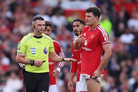 Harry Maguire of Manchester United speaks with Michael Oliver as they wait to reveal a VAR decision