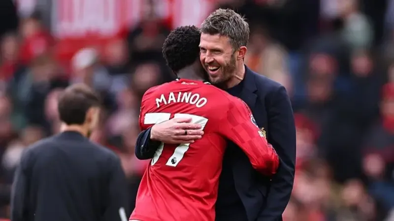 Manchester United head coach Michael Carrick with midfielder Kobbie Mainoo