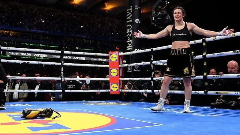 Katie Taylor places her gloves down in a boxing ring